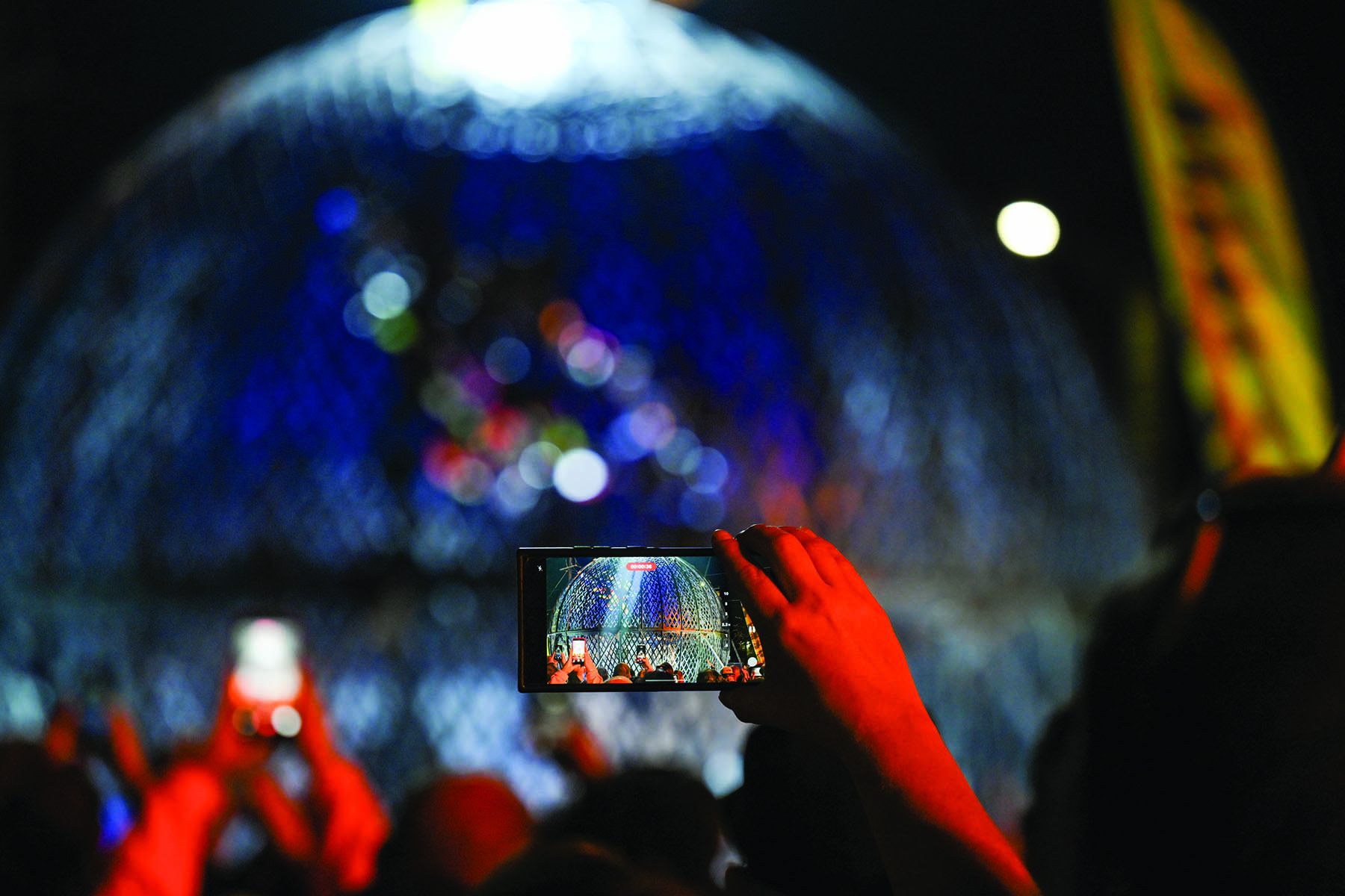 Person taking video on phone of motorcycle sphere